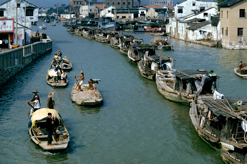 图为1973年北京王府井大街上推着自行车,带着孩子逛街的行人,当时人们