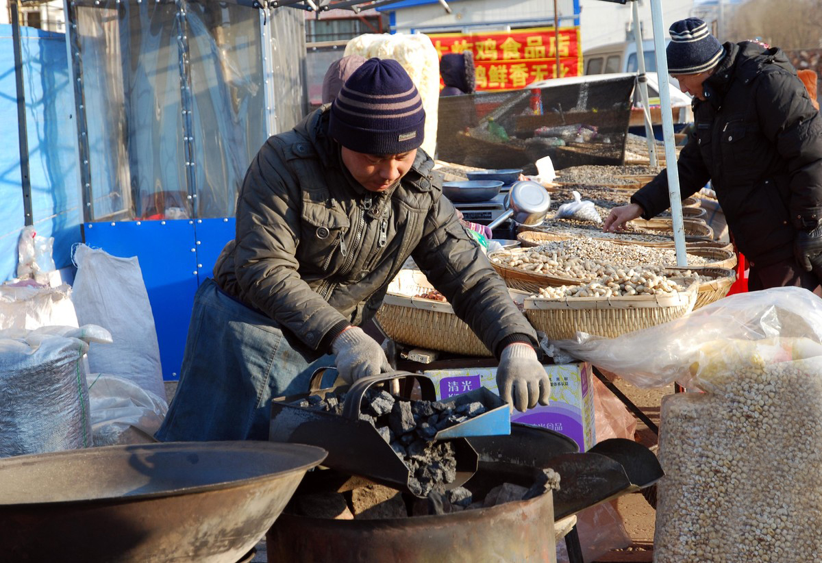 男子在农村集市上摆炒货摊,现炒现卖,笑称月赚2万没问题