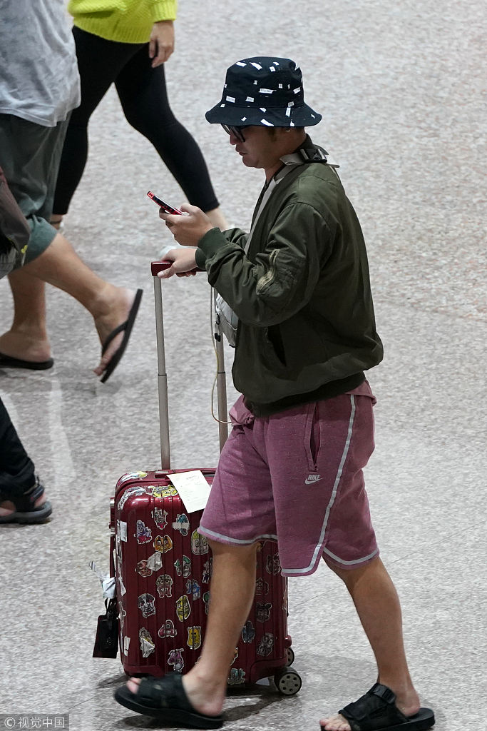 林柏升脚踩拖鞋戴渔夫帽亮相机场  一路看手机似乎给女友报平安