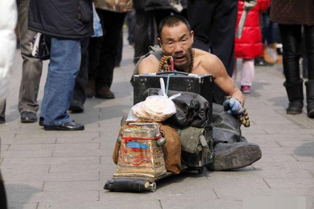 僧人打扮的乞丐在集市上行乞