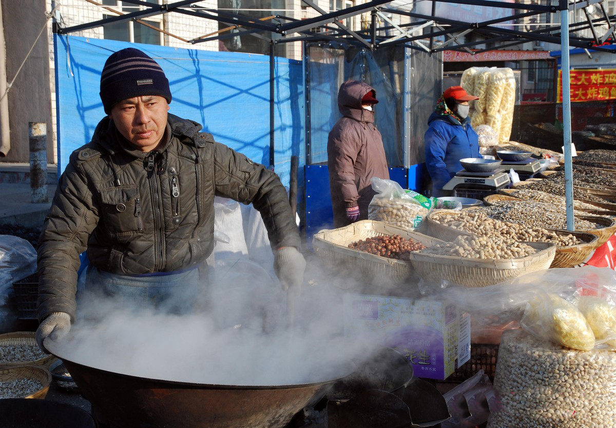 男子在农村集市上摆炒货摊,现炒现卖,笑称月赚2万没问题